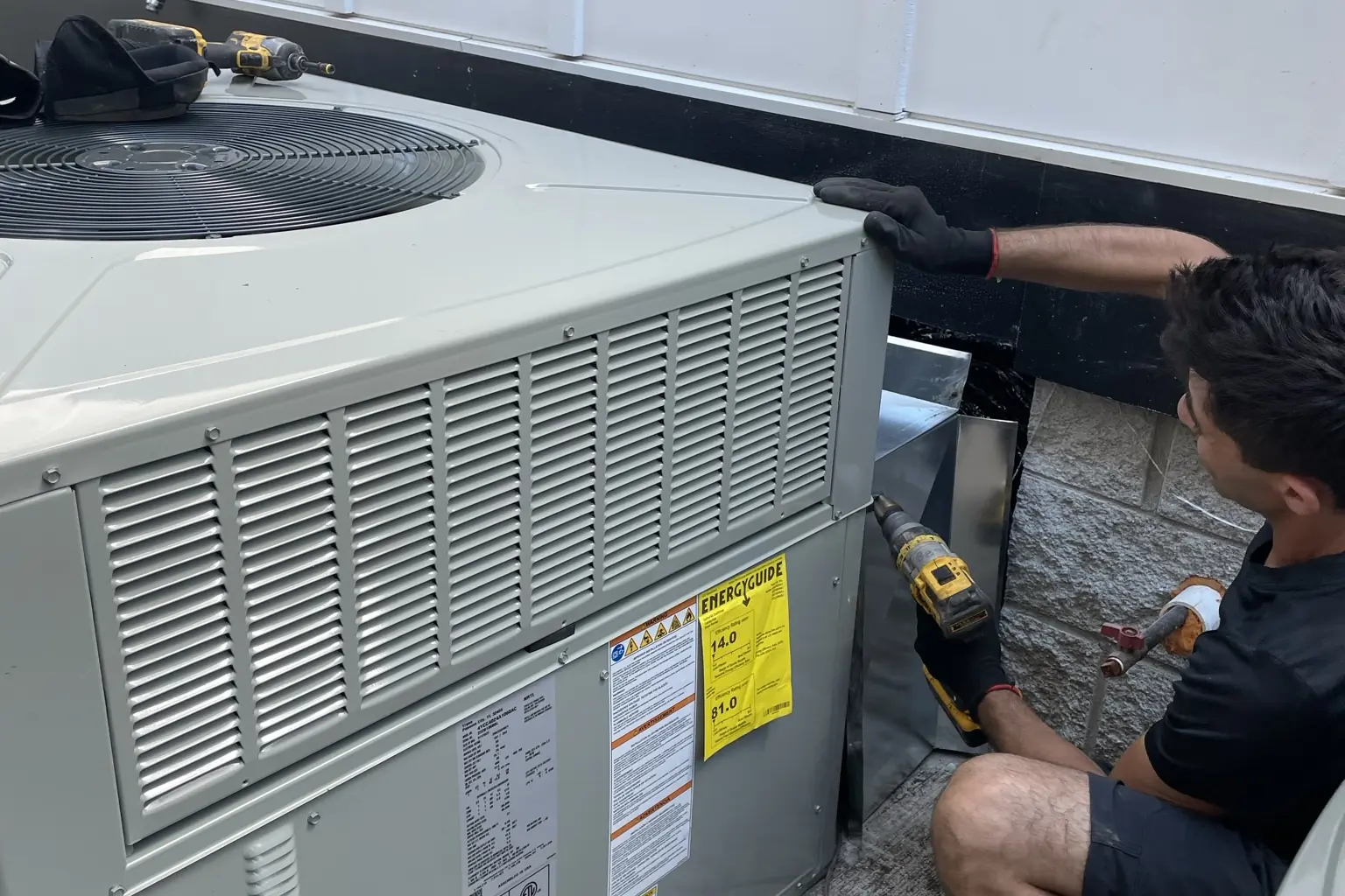 Modern Mechanical technician working on an outdoor heating and cooling unit at a residential property